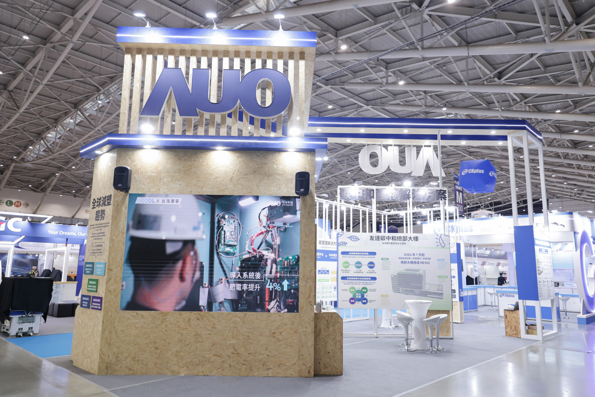 友達淨零碳排與新能源展位全面採用可回收材料，包含整體採鋁柱組合結構，搭配甘蔗板呈現溫潤木質色調，並以租賃桌椅進行現場陳設，實現源頭減量。